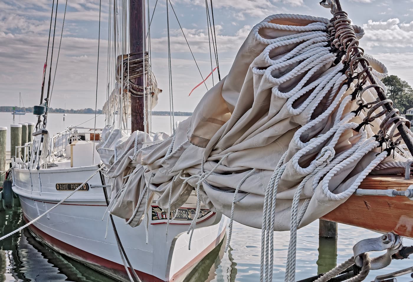 Cream canvas sail cover laced with rope on a heritage sailboat
