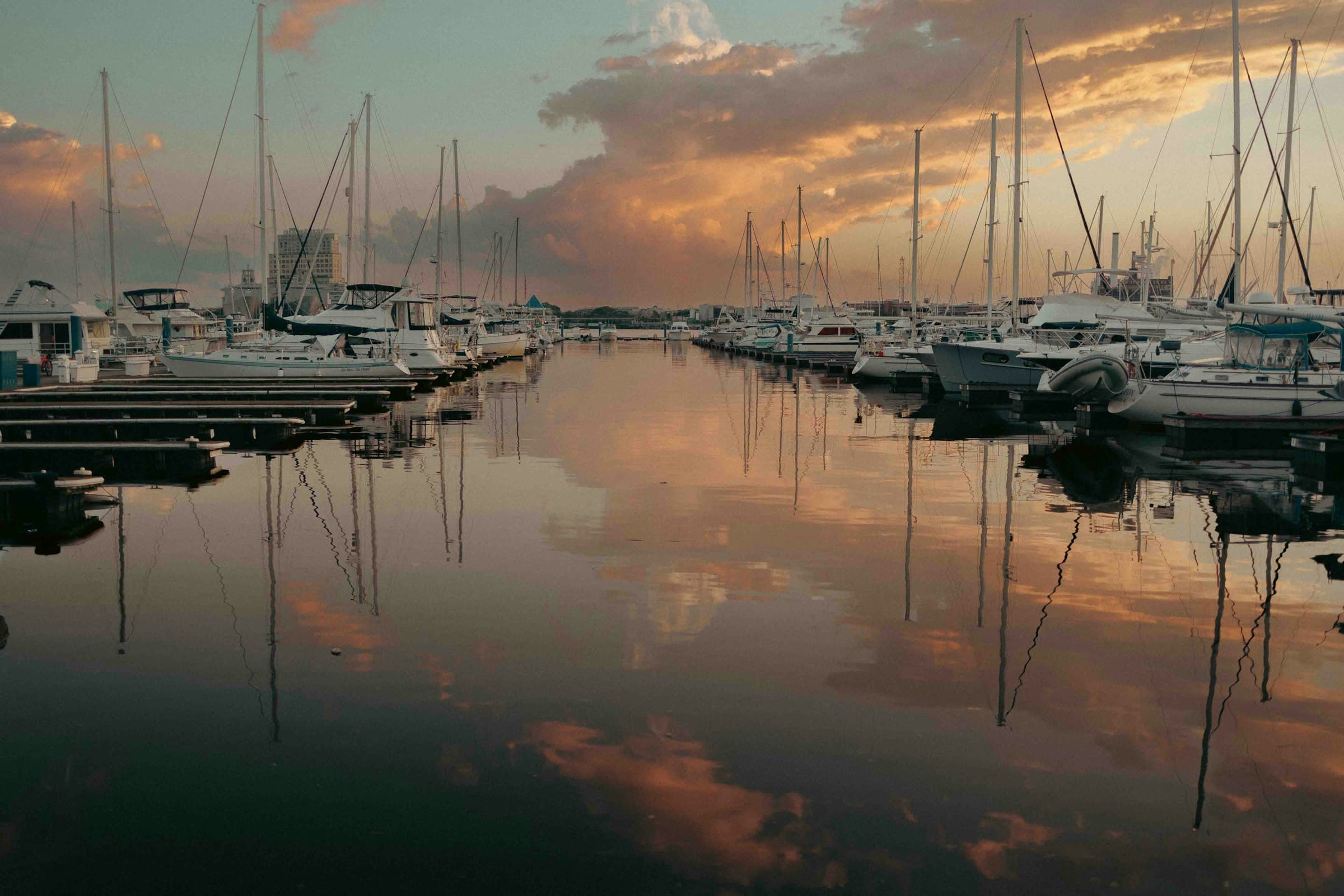 Boats moored at a calm marina at dusk