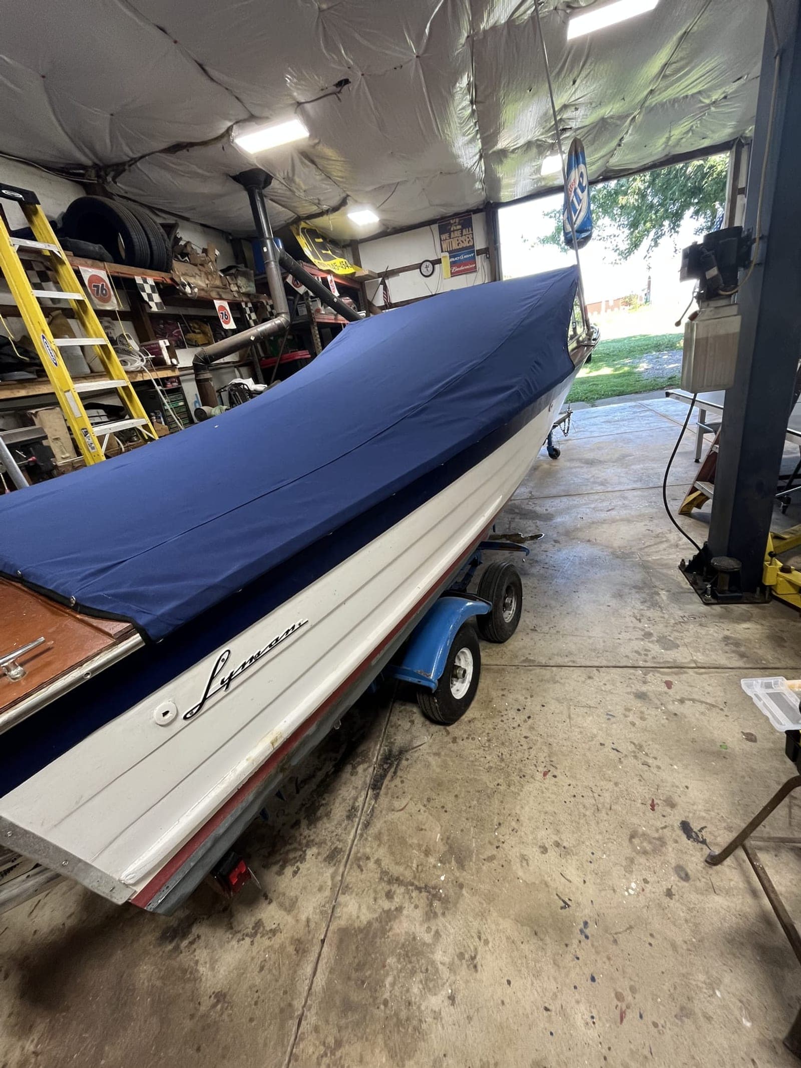 Classic Lyman wooden boat on a trailer in the Sew Right shop under a new navy custom mooring cover